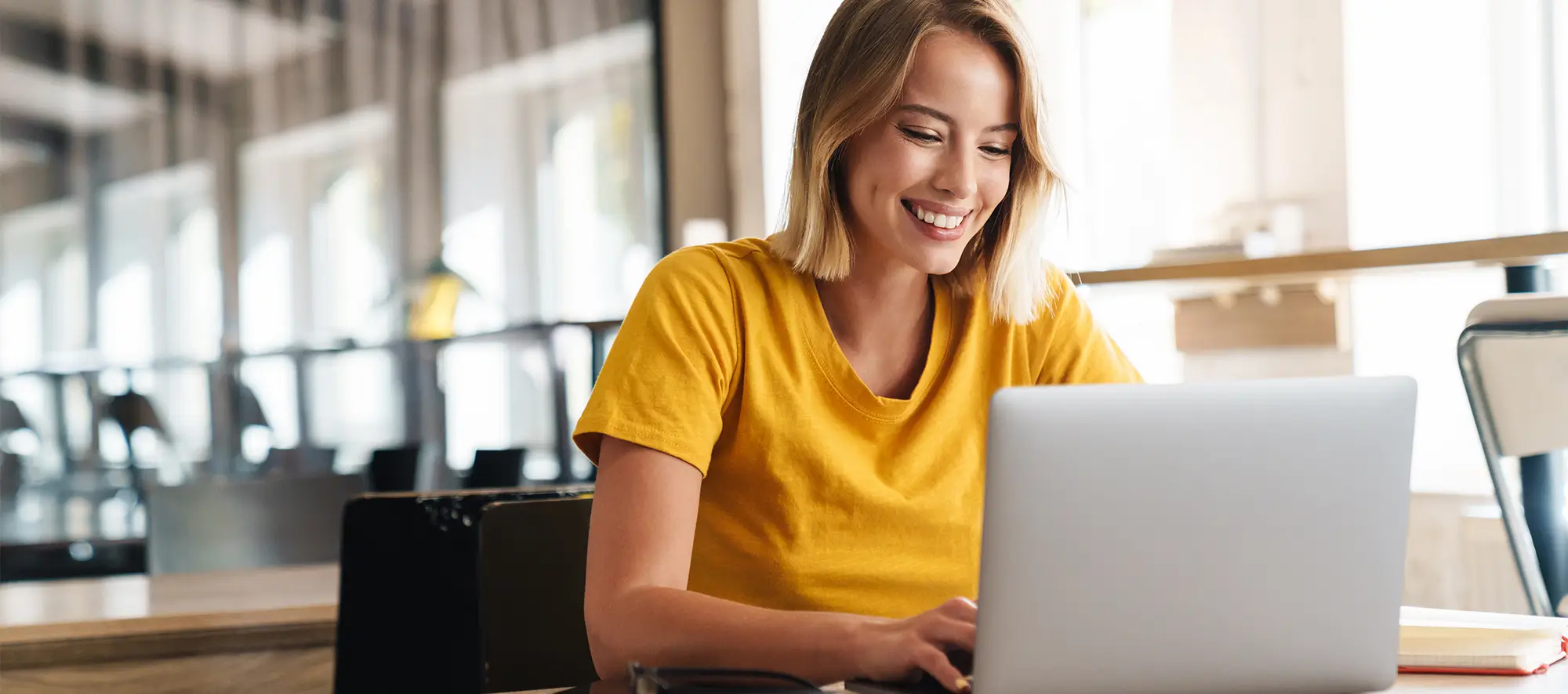 Woman smiling while using laptop.